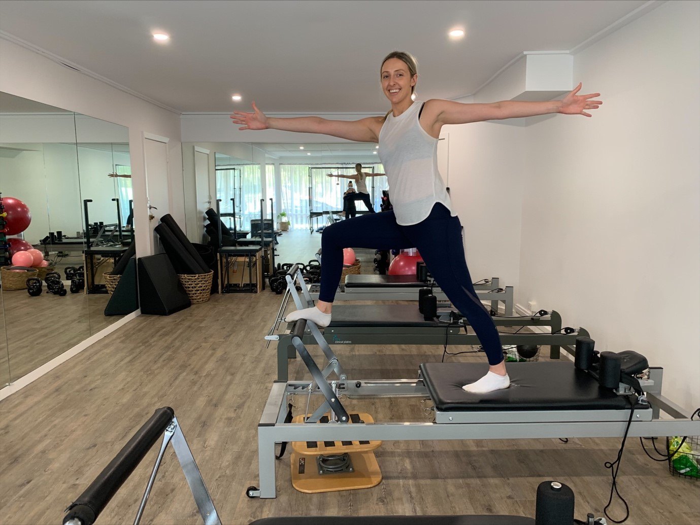 A physio working through a standing exercise on a reformer in our Pilates studio